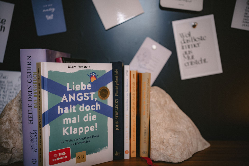 Bücher auf einem Tisch, darunter ein Buch mit dem Titel "Liebe Angst, halt doch mal die Klappe!"