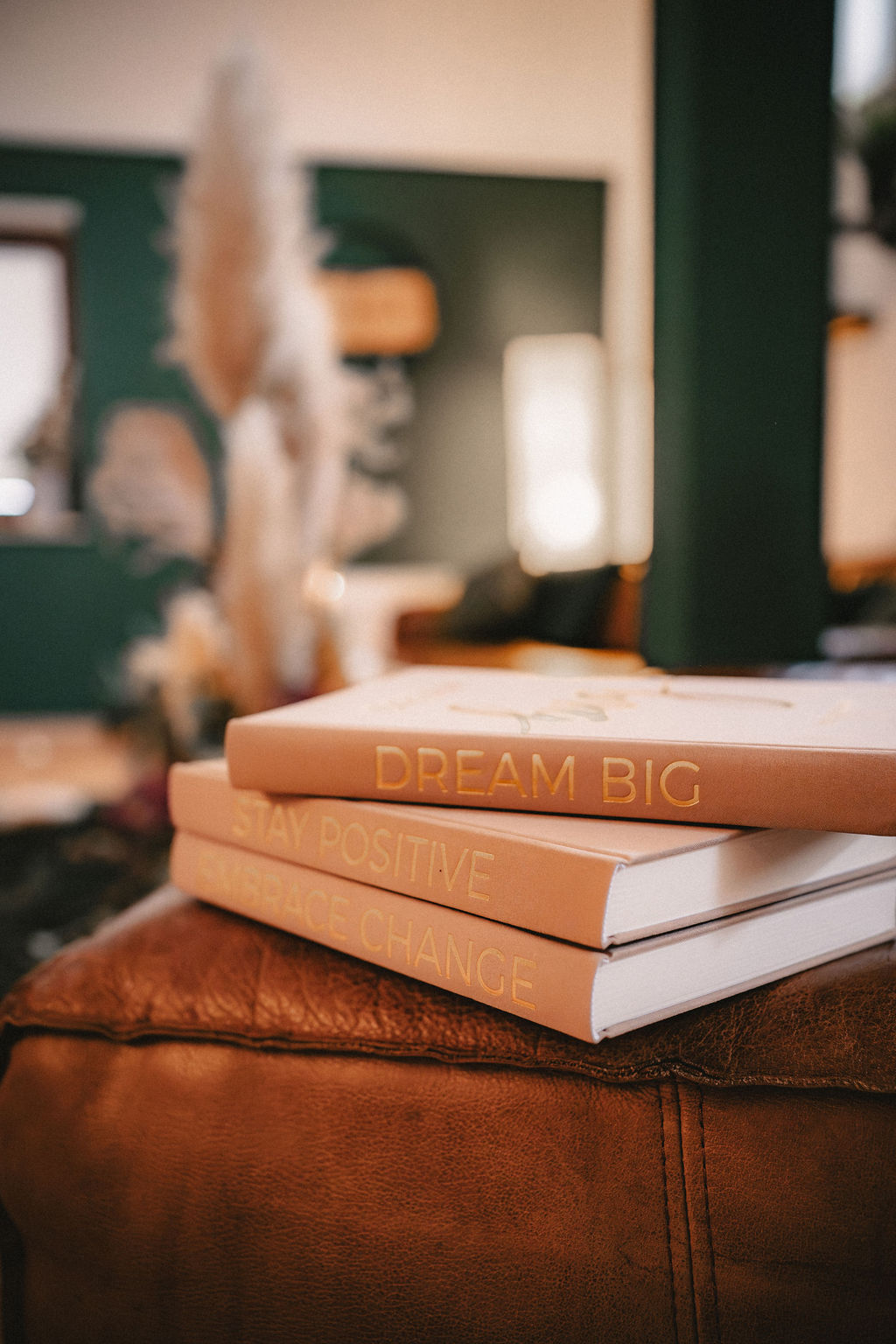 Ein offenes Buch liegt auf einem Sofa mit dekorativen Pflanzen im Hintergrund.