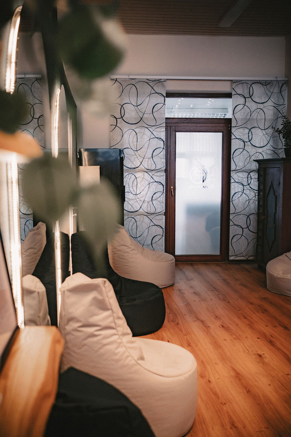 Ein Raum mit gemütlichen Sitzsäcken und einem Holzfußboden. Eine Glastür führt hinaus.