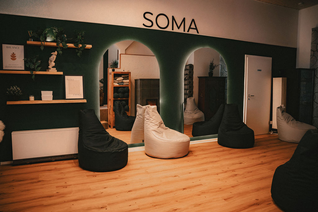 Modernes Interieur mit gemütlichen Sitzsäcken und einer Wand mit dem Schriftzug "SOMA".